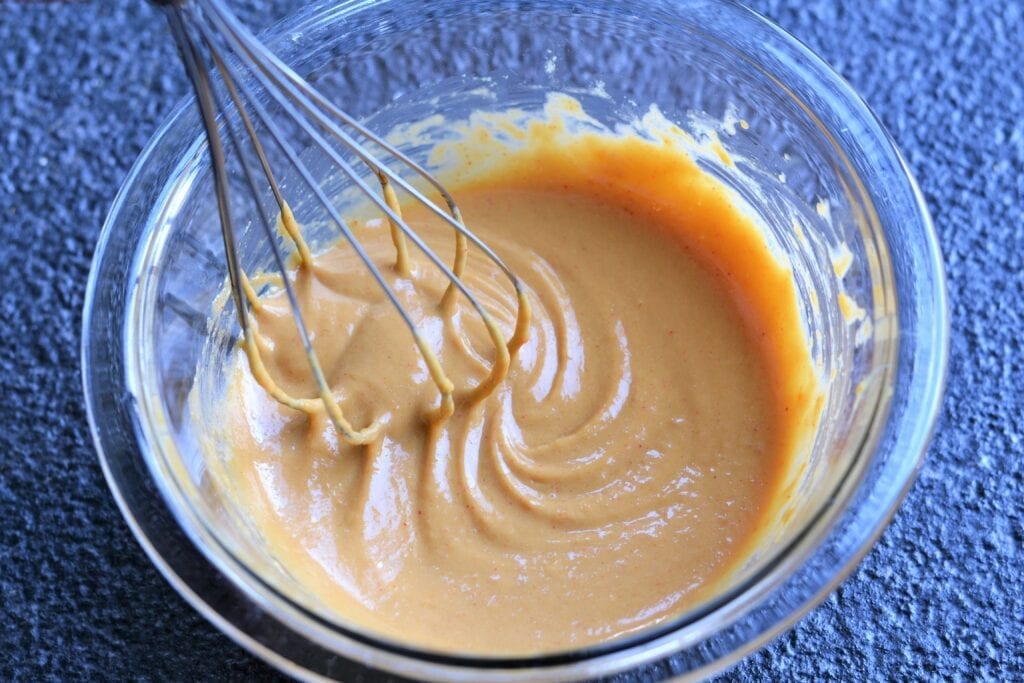 sesame sauce in a bowl with a whisk