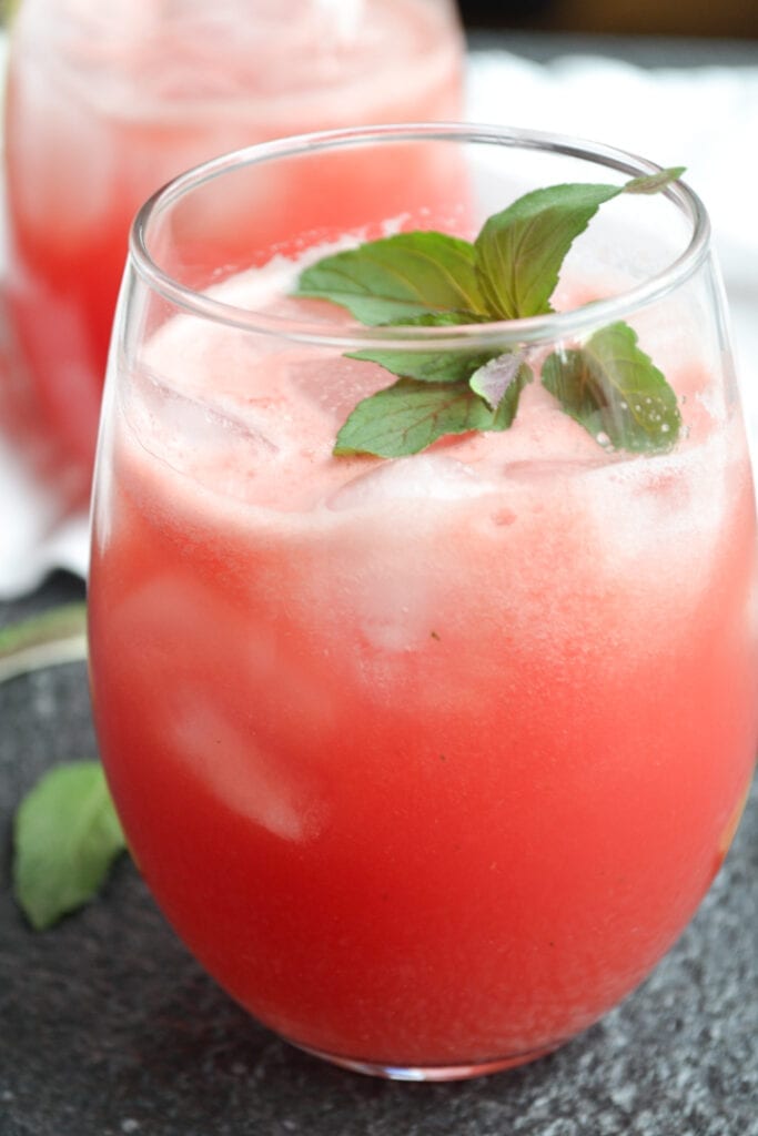 a glass of watermelon cooler with mint garnish
