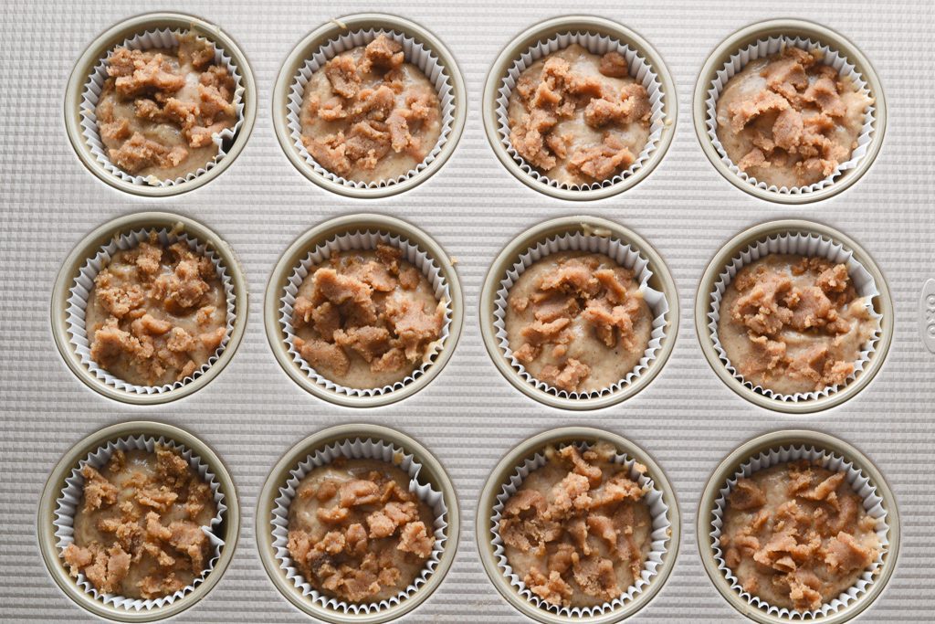 batter in muffin tins with streusel topping