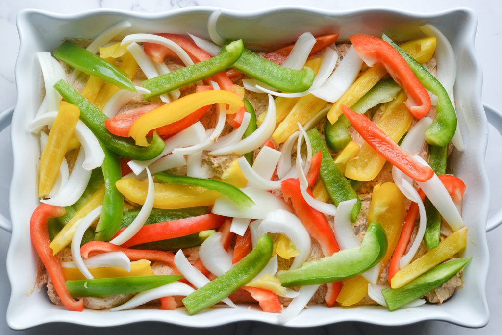 a baking dish with peppers and onions
